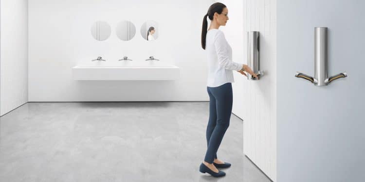 Femme utilisant le sèche mains Aiblade de Dyson dans des sanitaires publics