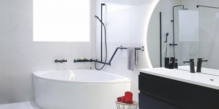 baignoire d'angle avec barres de maintien noires autour