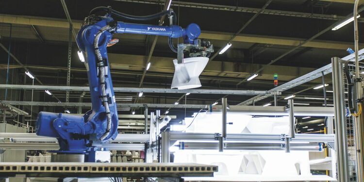 Robot soulevant un WC dans une usine Geberit