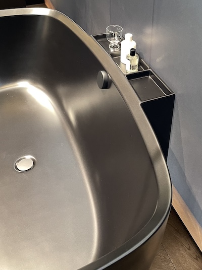 Baignoire noire Aurena de Duravit, au bord bisesauté et à la tablette de dépose des objets de toilette